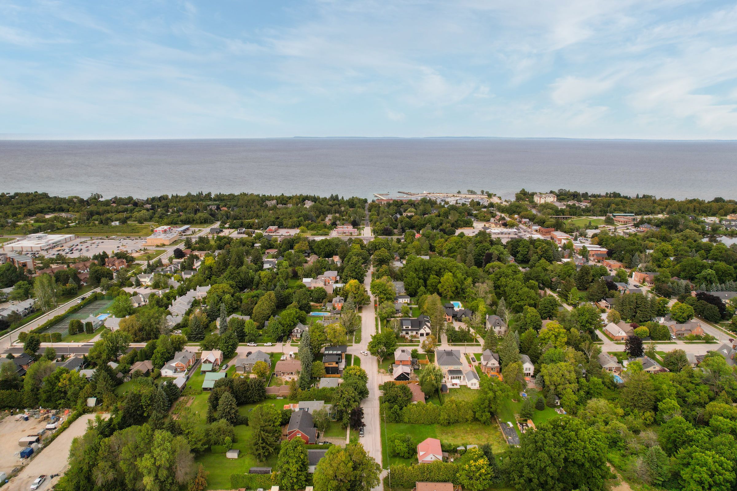 Wide aerial view across Thornbury and its tree canopy toward Georgian Bay.