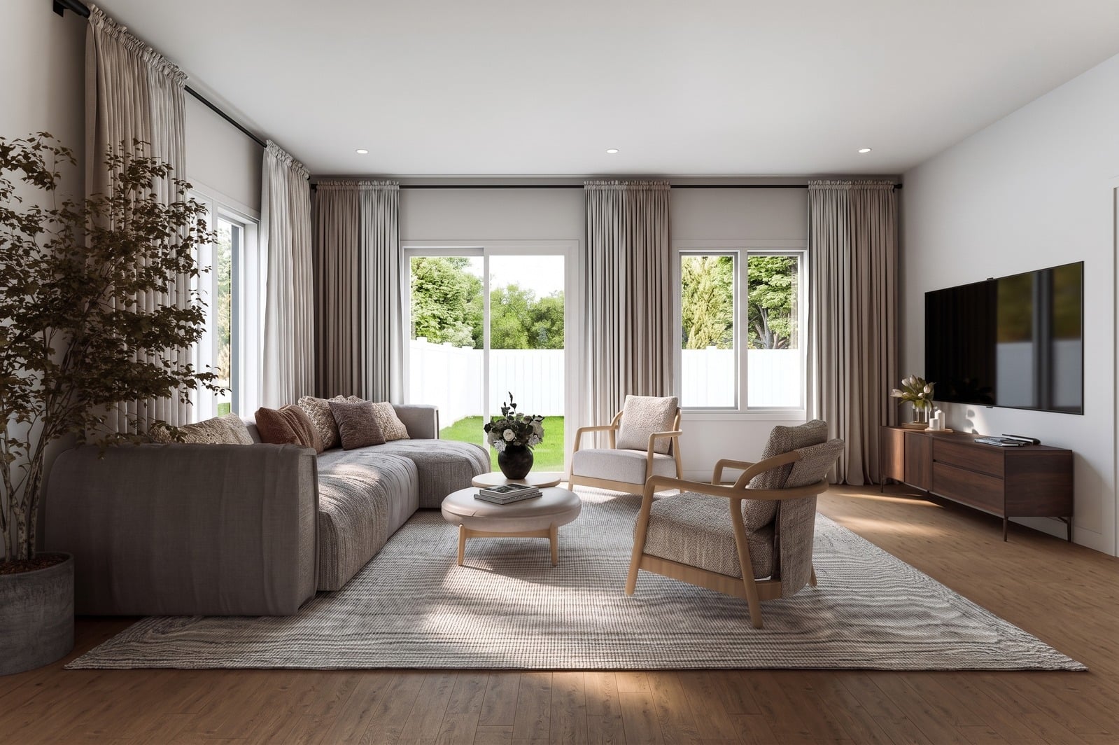 Sunlit Greenleaf living room with a sofa, lounge chairs and garden views.