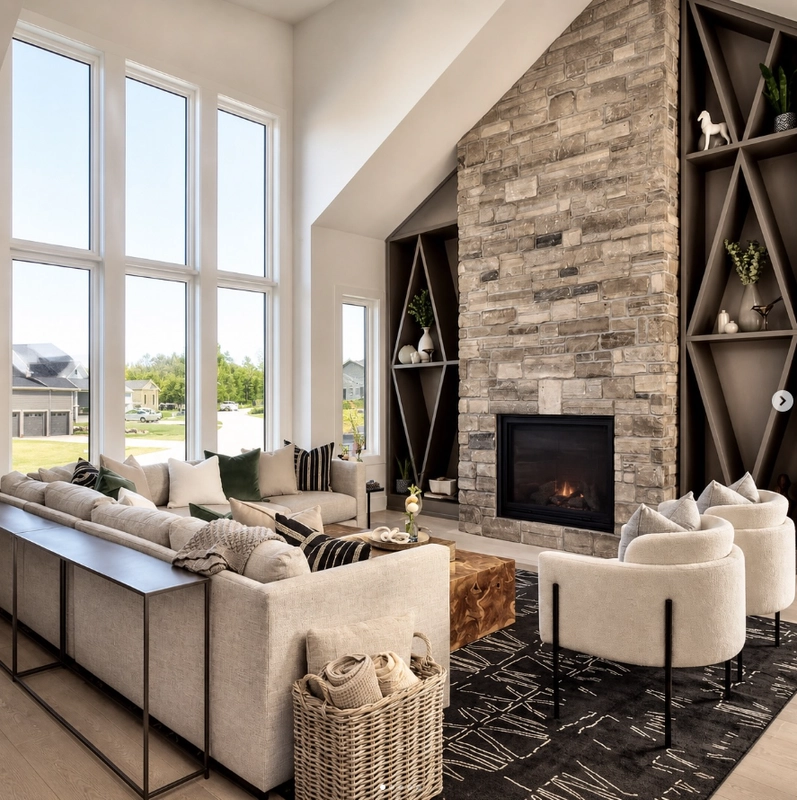 A light-filled living room with a floor-to-ceiling stone fireplace and built-in shelving.