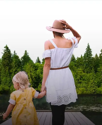 A woman and child looking over the lake from a wooden dock.